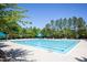 Beautiful community pool with clear blue water surrounded by trees and lounge seating at 92 Cardinal Ridge Rd, Chapel Hill, NC 27516