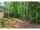 A partially finished backyard with a view of a raised wooden deck and surrounding wooded area at Lot 3260 Yorkshire Cir, Sanford, NC 27332