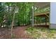 A partially finished backyard with a view of a raised wooden deck and surrounding wooded area at Lot 3260 Yorkshire Cir, Sanford, NC 27332
