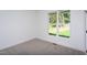 Bright bedroom featuring carpet, white walls, and a window with view of mature trees at Lot 3260 Yorkshire Cir, Sanford, NC 27332