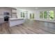 Open floor plan featuring a kitchen island with sink, white built-ins, and multiple windows at Lot 3260 Yorkshire Cir, Sanford, NC 27332