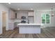 An open kitchen layout with gray cabinets, a center island, and views to the exterior at Lot 3260 Yorkshire Cir, Sanford, NC 27332