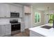 Spacious kitchen with stainless appliances, gray cabinets, and an island with a built-in sink at Lot 3260 Yorkshire Cir, Sanford, NC 27332