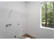 Well-lit laundry room featuring a window and shelving at Lot 3260 Yorkshire Cir, Sanford, NC 27332