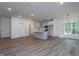 Bright open-concept living room featuring a kitchen with an island and hardwood floors at Lot 3260 Yorkshire Cir, Sanford, NC 27332