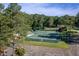 Overhead shot of community tennis courts nestled among trees with a parking lot and building nearby at Lot 3260 Yorkshire Cir, Sanford, NC 27332