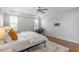 Bedroom with a tray ceiling, ceiling fan, and hardwood floors that catch light from two large windows at 10 Princeton Manor Dr, Youngsville, NC 27596