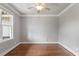 Bedroom with hardwood floors, crown molding, and bright natural light from a large window at 10 Princeton Manor Dr, Youngsville, NC 27596