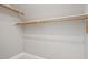 Walk-in closet with white walls and wooden shelving at 10 Princeton Manor Dr, Youngsville, NC 27596