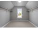 Walk-in closet with angled ceiling, with white walls, shelves, and wooden rods providing ample storage space at 10 Princeton Manor Dr, Youngsville, NC 27596