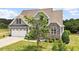Traditional style home with stone facade, neutral colors, black shutters and an attached garage at 10 Princeton Manor Dr, Youngsville, NC 27596