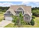 Beautiful two-story home featuring a stone facade, manicured landscaping, and a welcoming front porch, offering great curb appeal at 10 Princeton Manor Dr, Youngsville, NC 27596