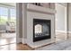 Elegant fireplace with white tile surround and view into sunroom at 10 Princeton Manor Dr, Youngsville, NC 27596