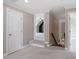 Hallway with carpet flooring, white trim, and doorways leading to various rooms and staircase at 10 Princeton Manor Dr, Youngsville, NC 27596