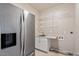 Laundry room with stainless steel refrigerator, folding counter, wash sink, and storage shelves at 10 Princeton Manor Dr, Youngsville, NC 27596