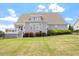 Back exterior view of a grey home with white trim, a deck, and a fenced yard at 10 Princeton Manor Dr, Youngsville, NC 27596