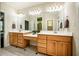 Large bathroom with dual sinks, wood cabinets, and a big mirror with vanity lighting at 100 Panoramic Ct, Cary, NC 27519