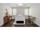 Bedroom with wood floors, white trim, a fan, and a bed between two windows at 100 Panoramic Ct, Cary, NC 27519