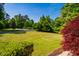 An exterior view showing an expansive, well-manicured front lawn and mature trees at 100 Panoramic Ct, Cary, NC 27519