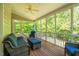 Inviting screened-in porch featuring comfortable seating, ceiling fan, and serene views of the surrounding nature at 100 Panoramic Ct, Cary, NC 27519