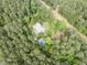 Aerial view of a private home with a pool nestled in a lush forest at 1000 Phils Creek Rd, Chapel Hill, NC 27516