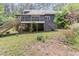 Spacious backyard with wooden deck, stairs, and lush greenery; providing a serene and private outdoor space at 1000 Phils Creek Rd, Chapel Hill, NC 27516