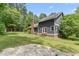 Backyard of home with mature trees and lush green grass at 1000 Phils Creek Rd, Chapel Hill, NC 27516