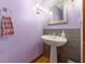 Powder room featuring a pedestal sink, decorative mirror, and lavender walls at 1000 Phils Creek Rd, Chapel Hill, NC 27516