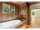 This wooden paneled bathroom shows a hot tub, cabinet space, and a window to let natural light in at 1000 Phils Creek Rd, Chapel Hill, NC 27516