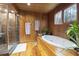 Wood paneled bathroom featuring a soaking tub and separate glass shower at 1000 Phils Creek Rd, Chapel Hill, NC 27516