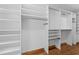 A walk-in closet features white wooden shelves and laminate wood floors with an organized storage system at 1000 Phils Creek Rd, Chapel Hill, NC 27516