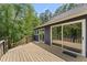 Spacious wooden deck with glass doors and windows provides an outdoor retreat surrounded by trees and greenery at 1000 Phils Creek Rd, Chapel Hill, NC 27516