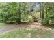 Gravel driveway surrounded by lush green trees provides a secluded entrance to the property at 1000 Phils Creek Rd, Chapel Hill, NC 27516