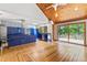 Kitchen with sleek blue cabinets, wooden ceiling and floor, plus a glass door to the deck at 1000 Phils Creek Rd, Chapel Hill, NC 27516