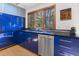 Modern kitchen featuring blue cabinets, stainless steel appliances, and a window looking to the outside at 1000 Phils Creek Rd, Chapel Hill, NC 27516