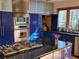 Modern kitchen featuring a black island, stainless steel appliances, and unique blue cabinets at 1000 Phils Creek Rd, Chapel Hill, NC 27516