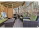 Covered patio area with wooded views, comfortable seating, and a dining space at 1000 Phils Creek Rd, Chapel Hill, NC 27516