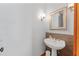 Powder room featuring a pedestal sink, decorative mirror, and stylish sconce lighting at 1000 Phils Creek Rd, Chapel Hill, NC 27516