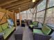 Relaxing screened porch with ample seating, a dining table, and views of the backyard woods at 1000 Phils Creek Rd, Chapel Hill, NC 27516