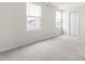 Spacious bedroom with neutral carpet, two windows, and a closet at 1012 Old Evergreen Dr, Durham, NC 27704