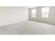 Spacious bedroom featuring two windows and plush carpet at 1012 Old Evergreen Dr, Durham, NC 27704