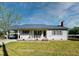 Charming single-story home featuring a carport, covered front porch, light siding and green shutters at 107 N Pearl St, Princeton, NC 27569