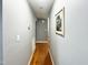 Hallway with hardwood floors and grey walls, leading to other rooms at 107 N Pearl St, Princeton, NC 27569