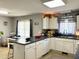 Bright kitchen with white cabinets, neutral walls, a breakfast bar and views to an eating area at 107 N Pearl St, Princeton, NC 27569