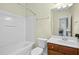 Bright bathroom featuring a shower-tub combo, classic vanity, and a view into the laundry area at 1103 Weston Green Loop, Cary, NC 27513
