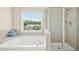 Bright bathroom featuring a soaking tub, glass enclosed shower, and natural lighting at 1103 Weston Green Loop, Cary, NC 27513