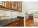 Open kitchen featuring granite countertops, wood cabinets, and hardwood floors at 1103 Weston Green Loop, Cary, NC 27513