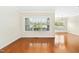 Spacious living room with large window providing ample natural light and hardwood flooring at 1103 Weston Green Loop, Cary, NC 27513