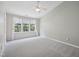 A bright, spacious bedroom features a ceiling fan, plush carpet, and backyard views at 111 Grey Elm Trl, Durham, NC 27713