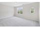 This spacious bedroom is brightly lit with neutral walls and features a unique porthole window and plush carpet at 111 Grey Elm Trl, Durham, NC 27713